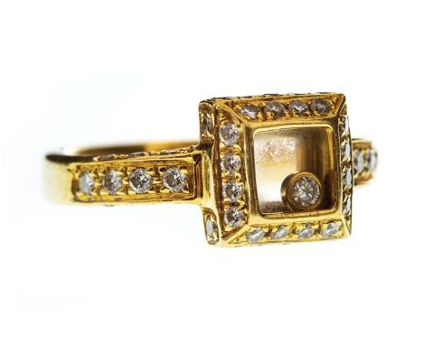 FLOATING DIAMOND RING, the square bezel with a collet set round brilliant cut diamond under crystal, bordered by round brilli