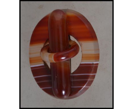 A vintage 20th century Scottish pebble banded orange agate brooch of pierced roundel form having a lozenge and ring to centre