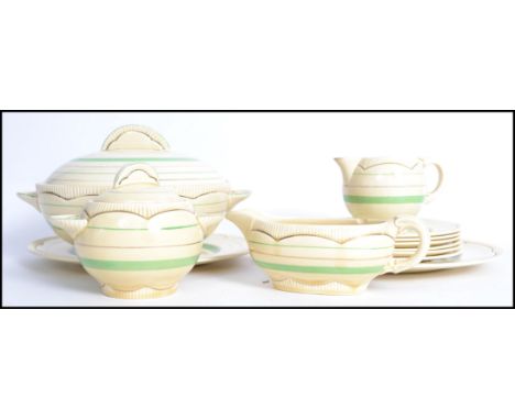 A vintage 20th century Clarice Cliff dinner service consisting of tureen, plates and side plates, gravy boat, jug, lidded bow
