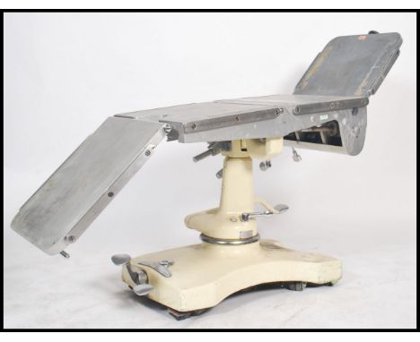 A good mid century Industrial / medical x-ray examination table having multiple folding steel adjustable bed with cushions ra