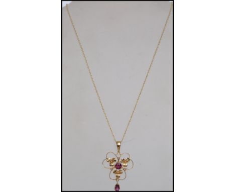 A 9ct gold Art Nouveau style pendant necklace the pendant decorated with clover leaves &nbsp;being set with purple stones str