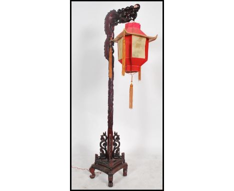 An unusual mid century Chinese hardwood dragon standard lamp having a carved details column with hanging decorative lantern.