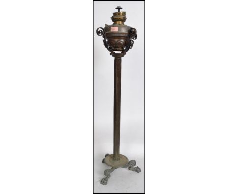 A 19th century brass neo classical oil lamp on stand. Raised on hairy paw feet with terraced plinth, reeded column with oil l