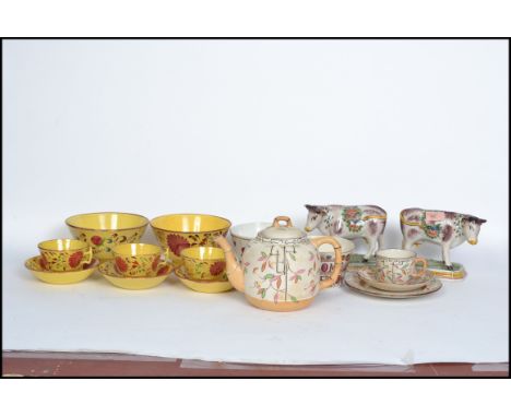 A collection of 19th century Victorian ceramics to include a pair of Staffordshire fireside cows raised on plinth bases, tea 