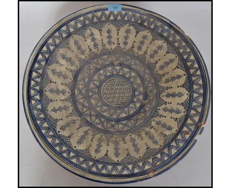 A large delft ceramic wall charger bowl in blue and white decorated with geometric patterns. Marked to the underside of the b