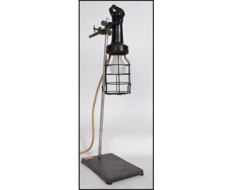 A stunning vintage mid 20th century industrial lab stand raised on a cast metal base and supporting a vintage bakelite inspec