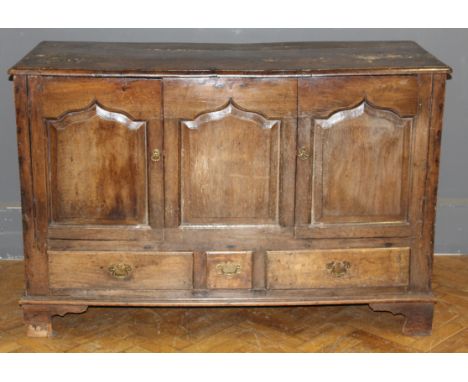 An 18th century oak mule chest, converted as a cupboard with fielded panel doors enclosing a single shelf, above three drawer