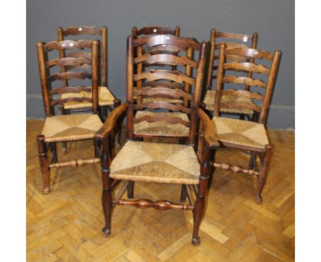 A matched set of seven 19th Century elm ladder back dining chairs, each with rush seat, (one carver)