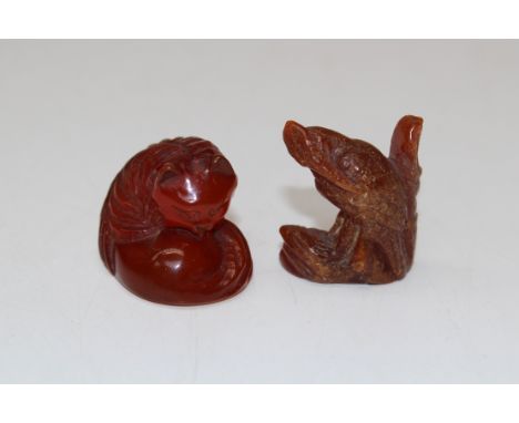 A Japanese amber-type netsuke, modelled as a Red Panda, signed, 3cm high together with a small carved amber model of a wading