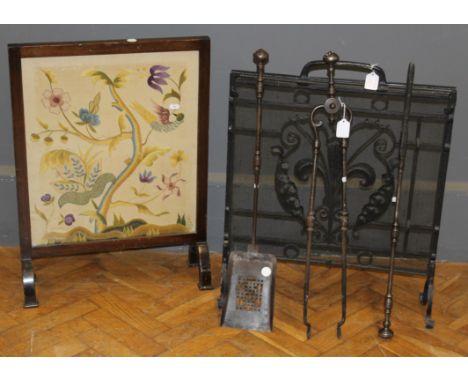 A wrought iron spark guard, 70 x 59cms, a set of three fire tools and a 1930s fire screen, set with crewelwork panel.&nbsp;&n