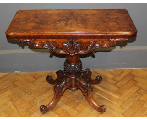 A Victorian figured walnut card table, the swivel folding top raised on turned column, four downswept legs, knuckle feet and 