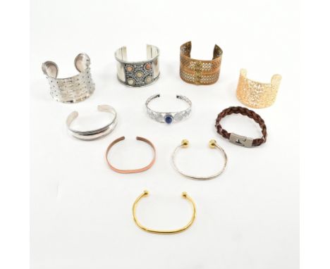 A collection of contemporary bangles. The bangle to include silver, silver and gold tone, gem set, pierced torque, leather cu