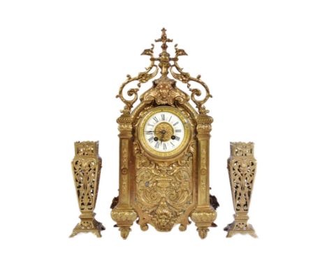 A 19th century French rococo revival ormolu mantel clock and garniture set. The clock decorated with scrollwork and featuring