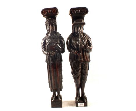 A pair of dark stained Oak wooden figures of a Pied Piper and a woman playing a tambourine, height 24 1/2"