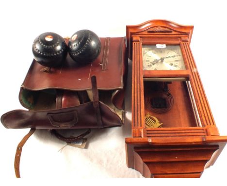 A modern wall clock plus a case of lawn bowls