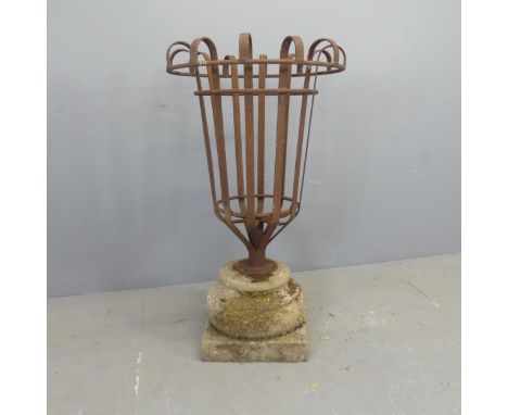 A wrought iron basket planter on weathered concrete plinth base. W58cm, H105cm. 