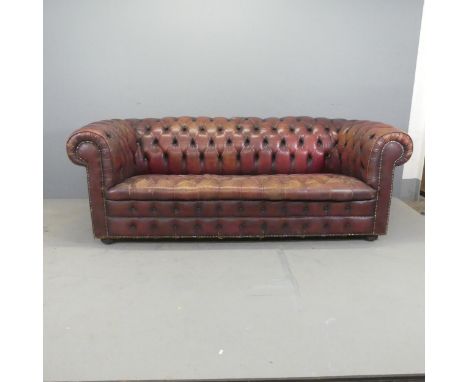 A buttonback studded oxblood leather upholsetered three-seater Chesterfield sofa. Overall W210cm, H75cm, D90cm, seat W153cm, 