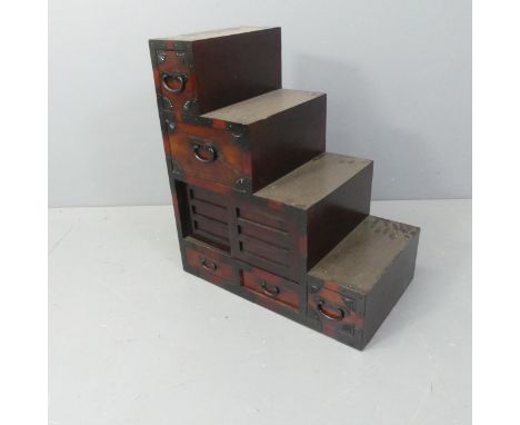 A modern Japanese centre-standing kiriwood step Tansu chest of five drawers, with two sliding doors. W64cm, H72cm, D37cm.The 