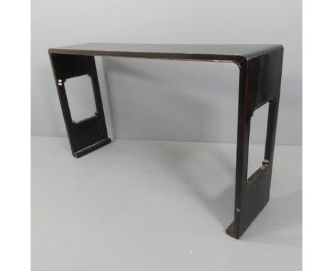 An antique Chinese black lacquered altar table or console table, the curved ended top supported on pierced ends with scroll f