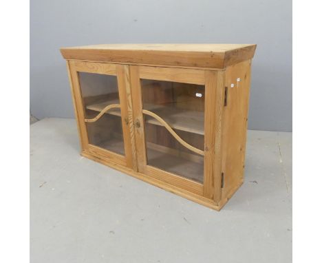 A modern pine low cabinet, with two glazed doors and shelf fitted interior. W103cm, H69cm, D32cm. 