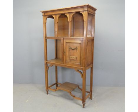 An early 20th century French cherrywood open bookcase / display cabinet, with single fielded panelled door, brass mounts and 