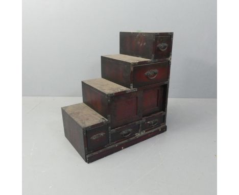 A modern Japanese kiriwood step Tansu chest of five drawers, with two sliding doors. W70cm, H76cm, D39cm. 