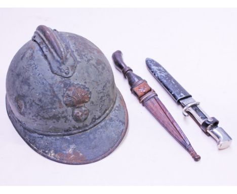 A mixed lot comprising a French WWI helmet, a Nazi Youth dagger and an african dagger. Condition - wear to helmet, nazi dagge