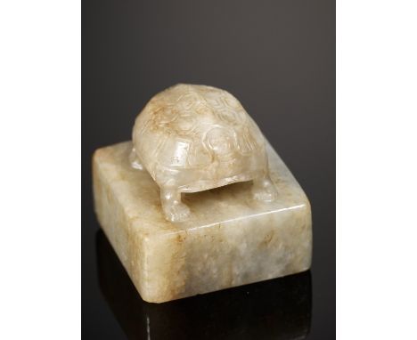 A CELADON JADE 'TURTLE' SEAL, 17TH CENTURY 十七世紀青玉龜鈕印China. The square seal surmounted by a turtle standing foursquare, its mi