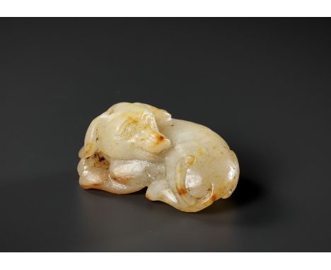 A PALE CELADON AND RUSSET JADE FIGURE OF A DOG, 17TH-18TH CENTURY 十七至十八世紀青玉帶皮臥犬China. The dog is carved with its hind legs tu