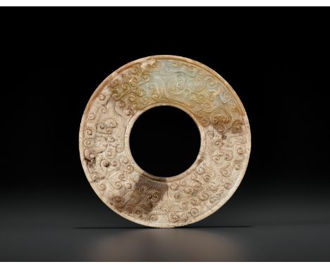 A JADE DISC, HUAN, EASTERN ZHOU DYNASTY 東周玉環China, 8th-3rd century BC. The disc is neatly decorated in low relief with archai