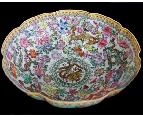 A Chinese porcelain egg shell bowl, printed with polychrome enamelling in famille rose colours with dragons amid peonies, red