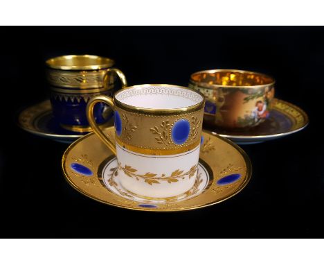 Two Limoges cabinet cups and saucers of small size, one with blue jewelling on a richly tooled gilt ground; the other cobalt 