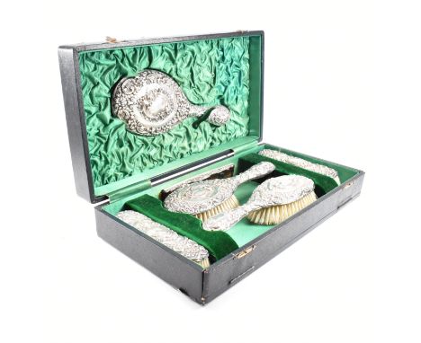 A Edwardian cased hallmarked silver mounted five piece vanity set with later comb. The Edward VII set comprising of two hair 