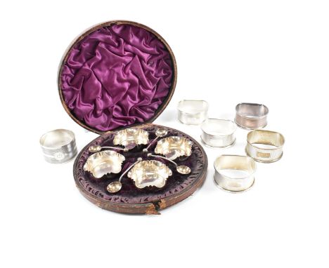 A Victorian cased set of four hallmarked silver salts and six napkin rings. The cased set of four Victorian silver salts hall