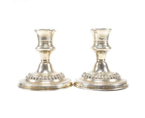 A pair of Edwardian Asprey and Co hallmarked silver candlesticks. The candlesticks having stepped weighted bases being of squ