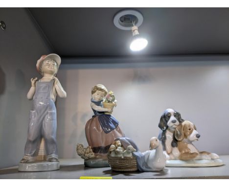 A group of Lladro and Nao porcelain figurines and animal model groups, to include one of a boy with an accordion by his feet,