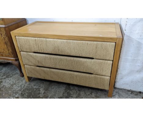 A modern light oak chest of three drawers, the drawer fronts with woven decoration, 75.5h x 120w 