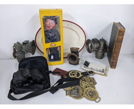 A mixed lot to include a Pelham puppet, china, horse brasses, binoculars, postcards, book, bike lamps and other items, Locati