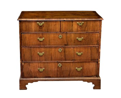 A George I and later walnut veneered five drawer chest, the cross banded moulded top over cross banded sides and two short ov