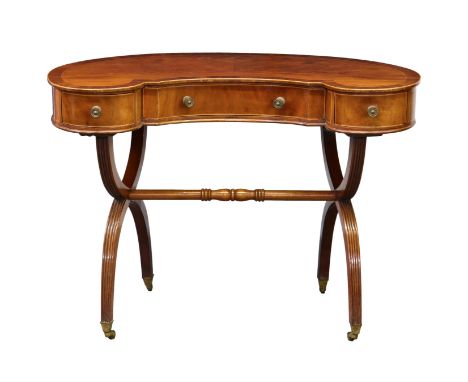 A George III style cross banded mahogany kidney shaped writing table, first half 20th century, with three drawers, raised on 