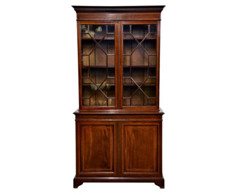 A good Edwardian mahogany and satinwood glazed cupboard bookcase, the dentil cornice over a satinwood banded frieze and pair 