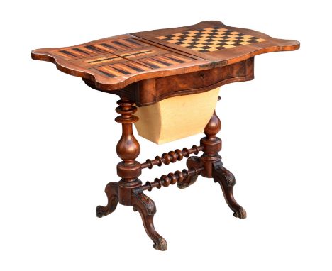 A Victorian burr walnut serpentine games and work table, the hinged swivel top with chess, backgammon and cribbage boards inl