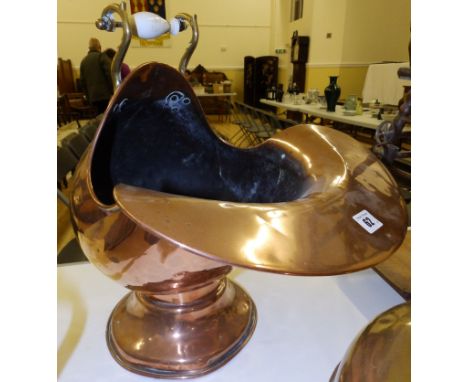 A helmet shaped copper coal scuttle
