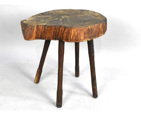 A Rustic Garden Stool Formed From a Section of Elm Tree Trunk on Four Turned Supports, 50cms High 