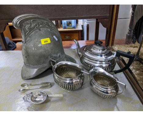 A Merryweather plated fireman's helmet, a silver plated three piece tea set, sugar tongs and strainersLocation: 