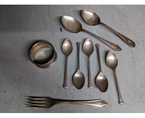 A group of silver flatware and a napkin ring to include a set of five coffee spoons, mixed dates and makers, total weight 106