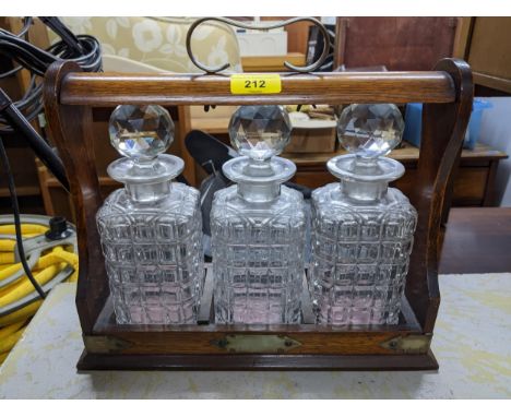 A Victorian oak cases and silver plated tantalus with three glass whiskey decanters and stoppers (no key)Location: 