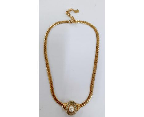 Christian Dior-A 1980's gold tone necklace having a central oval faux pearl pendant surrounded by small white rhinestones, to