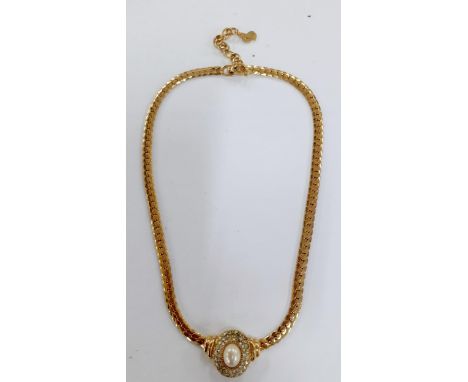 Christian Dior-A 1980's gold tone necklace having a central oval faux pearl pendant surrounded by small white rhinestones, to