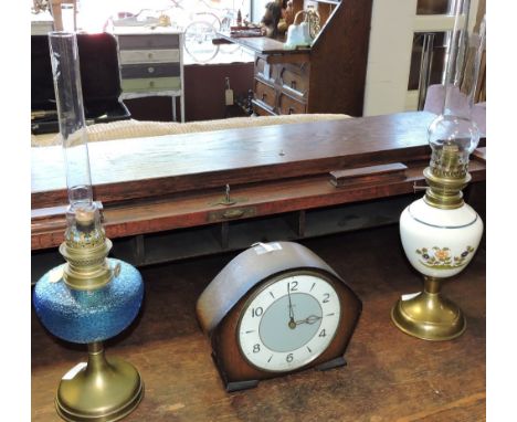 A 20th century Smiths oak cased mantel clock, the grey and white dial set out with Arabic numerals, together with two oil lam